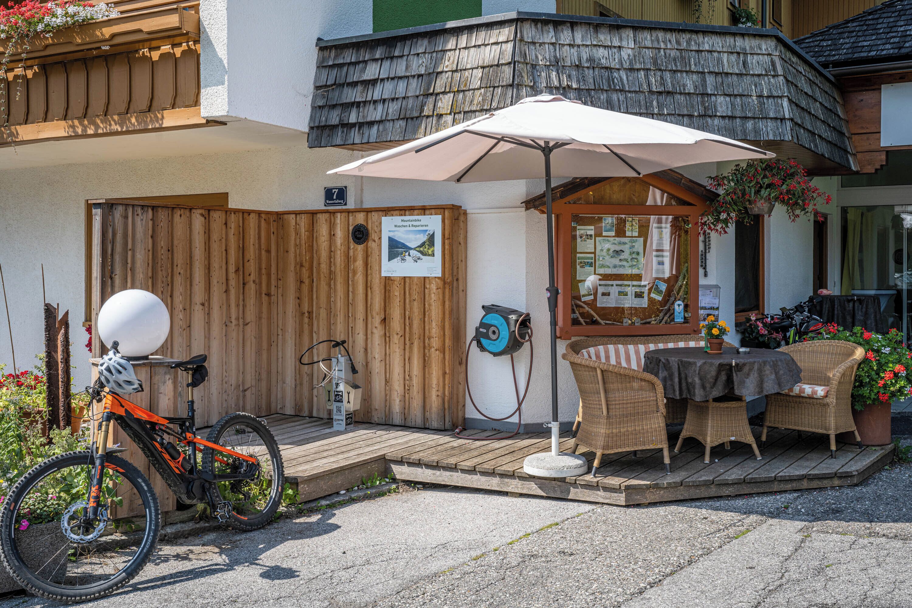 A wooden deck with a table and chairs, a bicycle, and a sign indicating a scenic view.