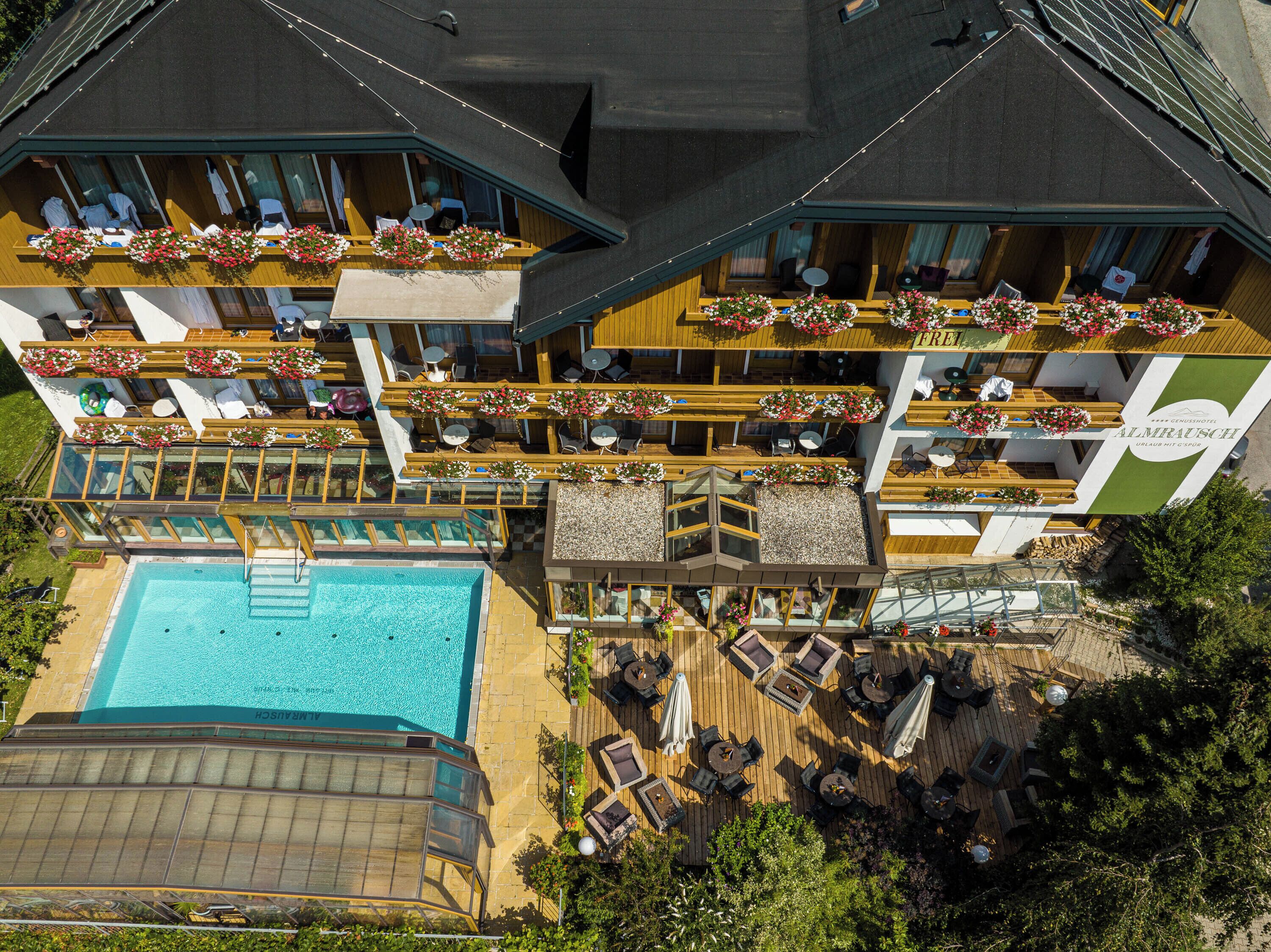Un hotel con varios balcones, piscina y zonas de estar al aire libre.