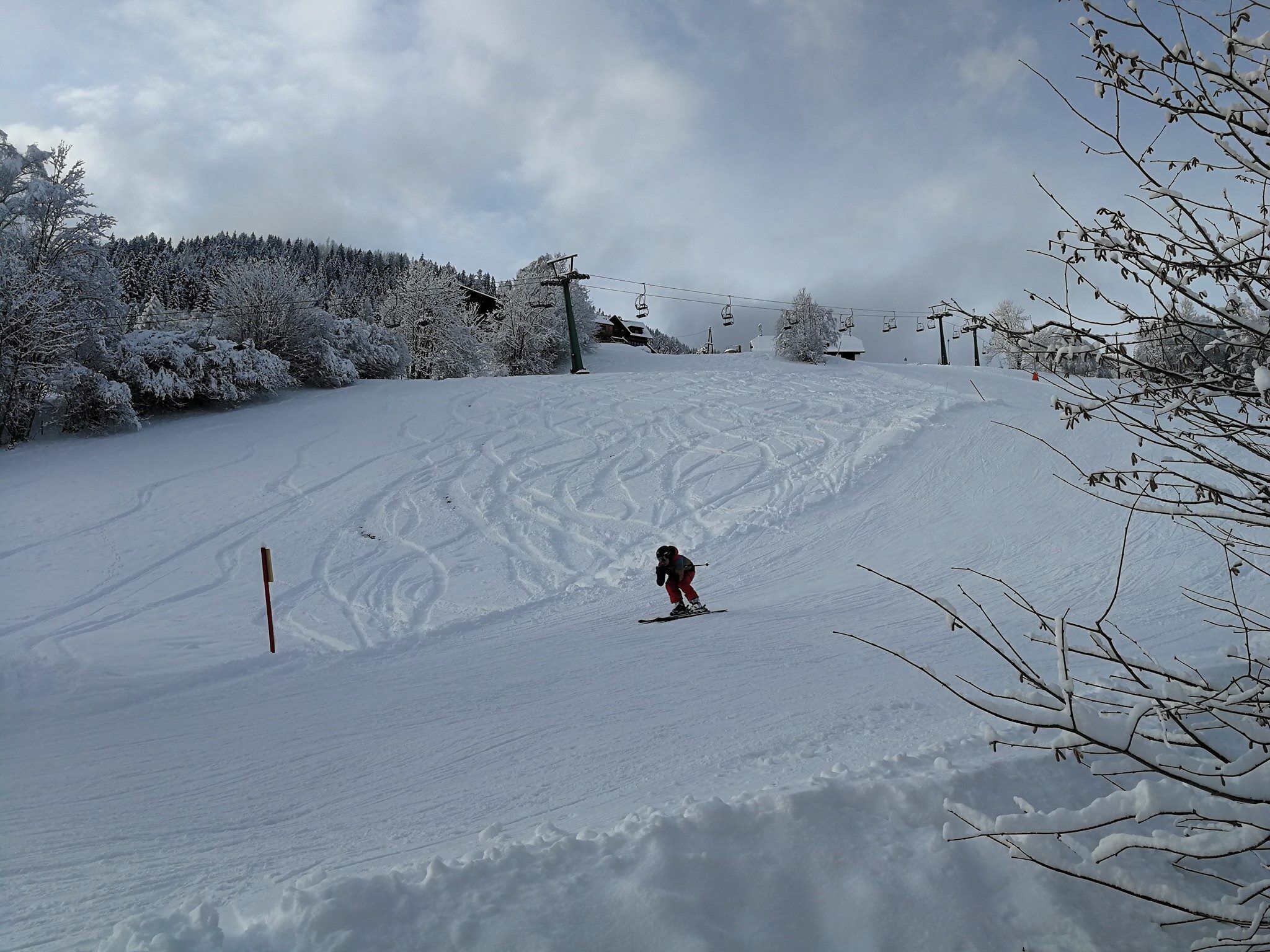 Una pista da sci innevata con un singolo sciatore.
