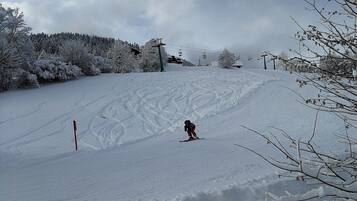Una pista da sci innevata con un singolo sciatore.