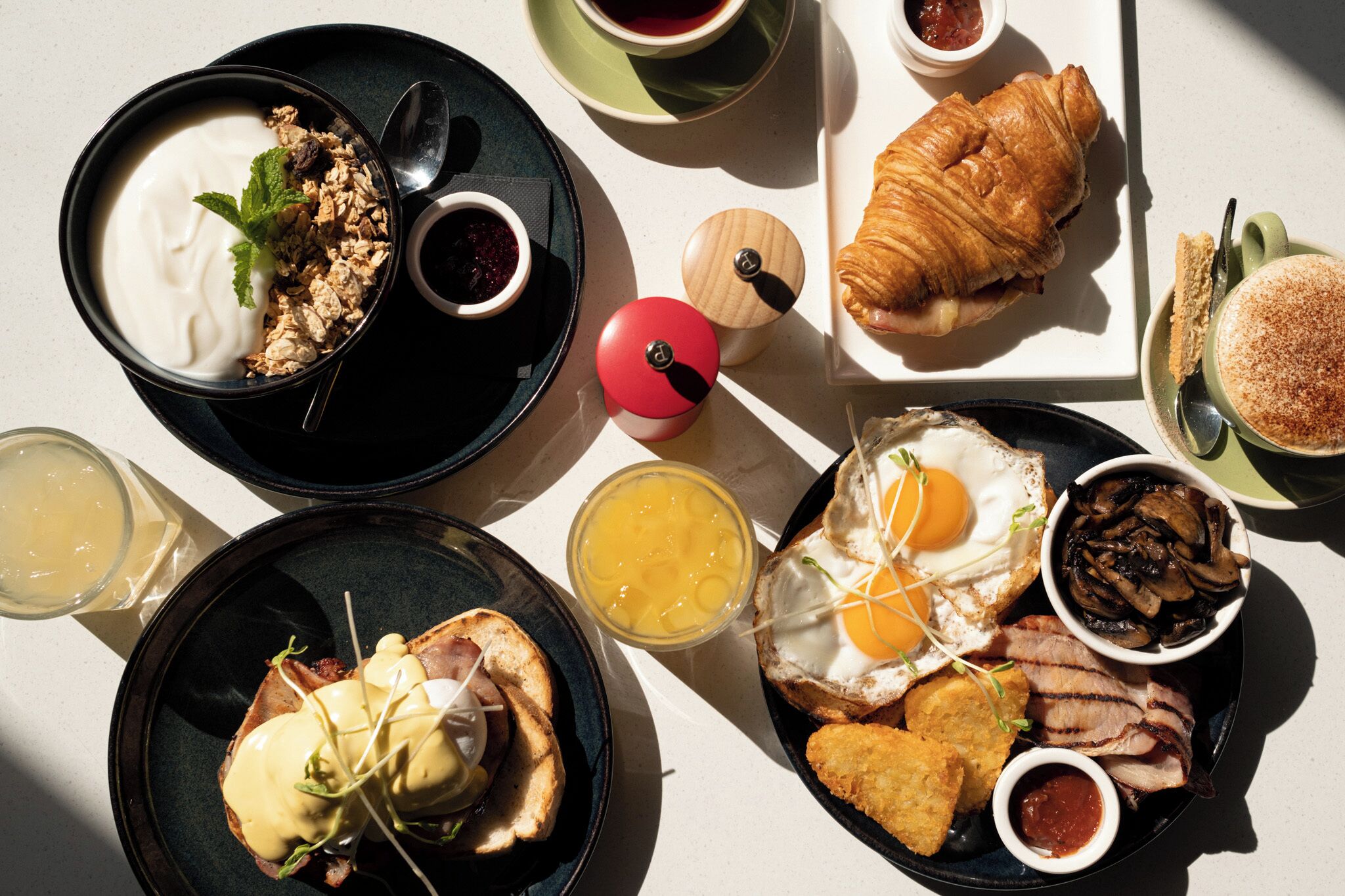 A breakfast spread with various dishes including eggs, croissants, and a variety of side items.