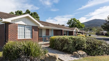 A row of brick houses with a gravel driveway and a small garden area.
