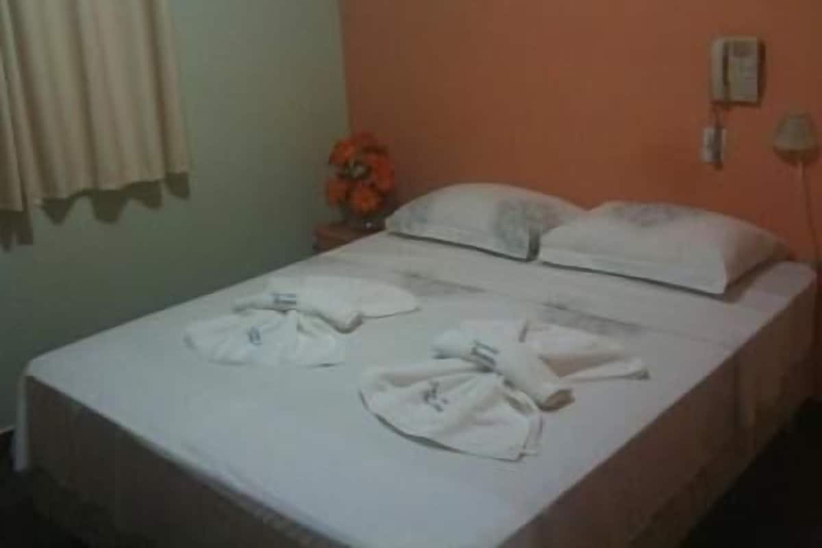 Ein Hotelzimmer mit einem Bett, einem Nachttisch und einem Telefon.