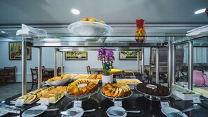 Un buffet con diversi cibi e un vaso di fiori viola.