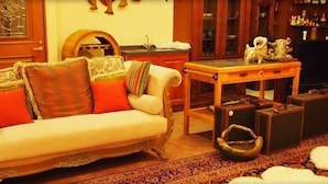 A living room with a sofa, a small table, and a television. - Petit Hotel Corinthian (Rebun)