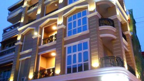 A multi-story hotel with balconies, outdoor seating, and a bar area. - Pillar Hotel (Phnom Penh)