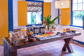 A buffet table with various food items and condiments.