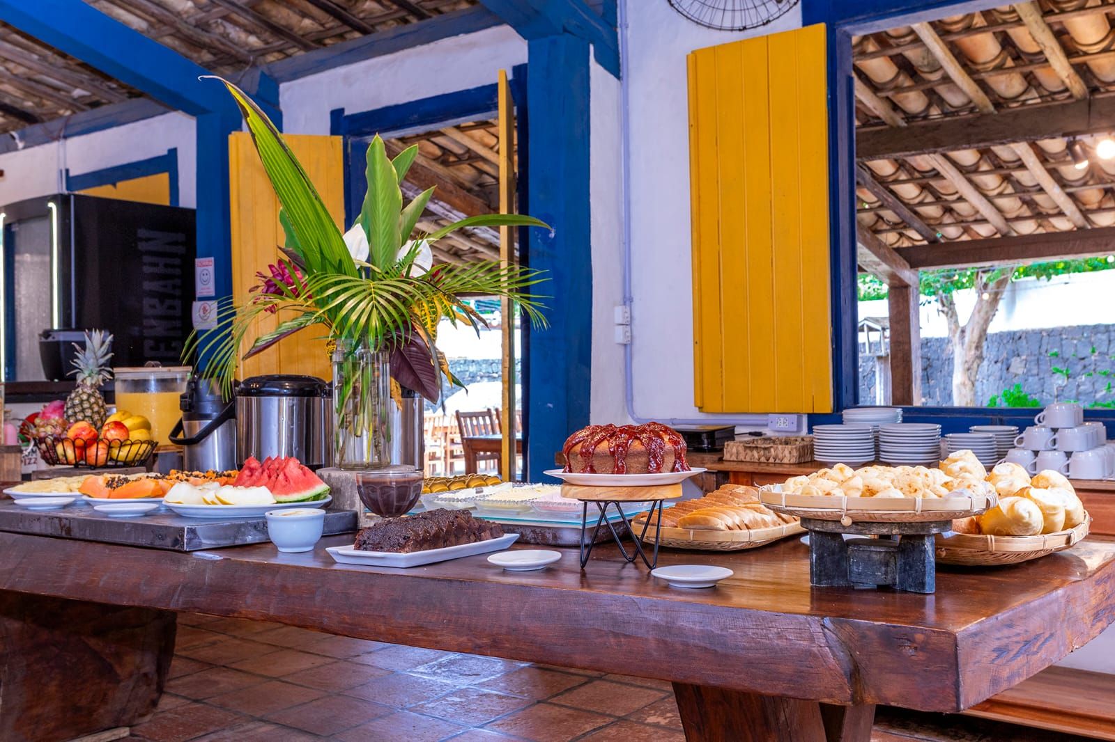 Una mesa de buffet con diversos alimentos y un centro de mesa con plantas.