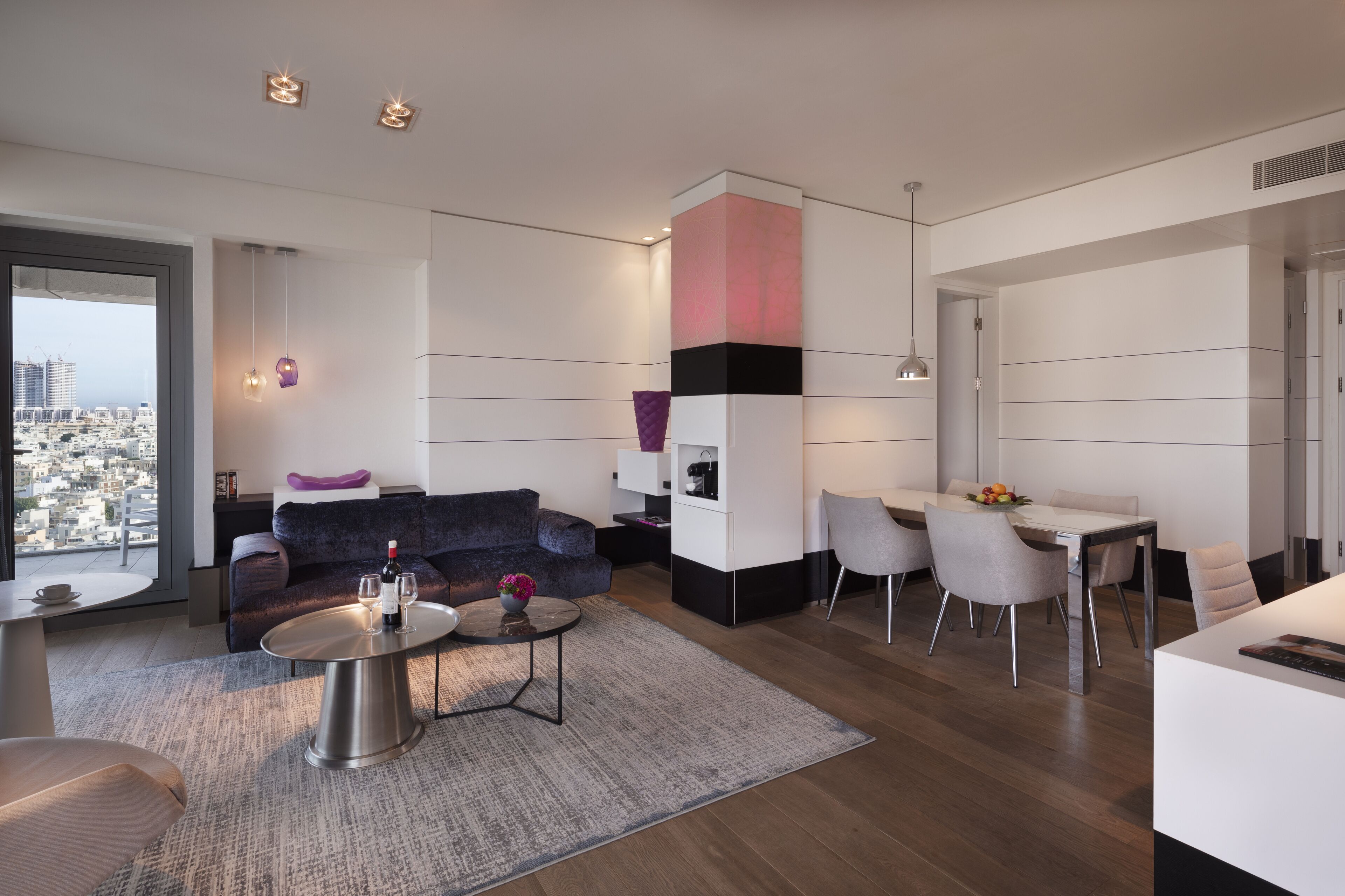 A modern living room with a sofa, coffee table, and dining area.