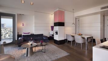 A modern living room with a sofa, coffee table, and dining area.