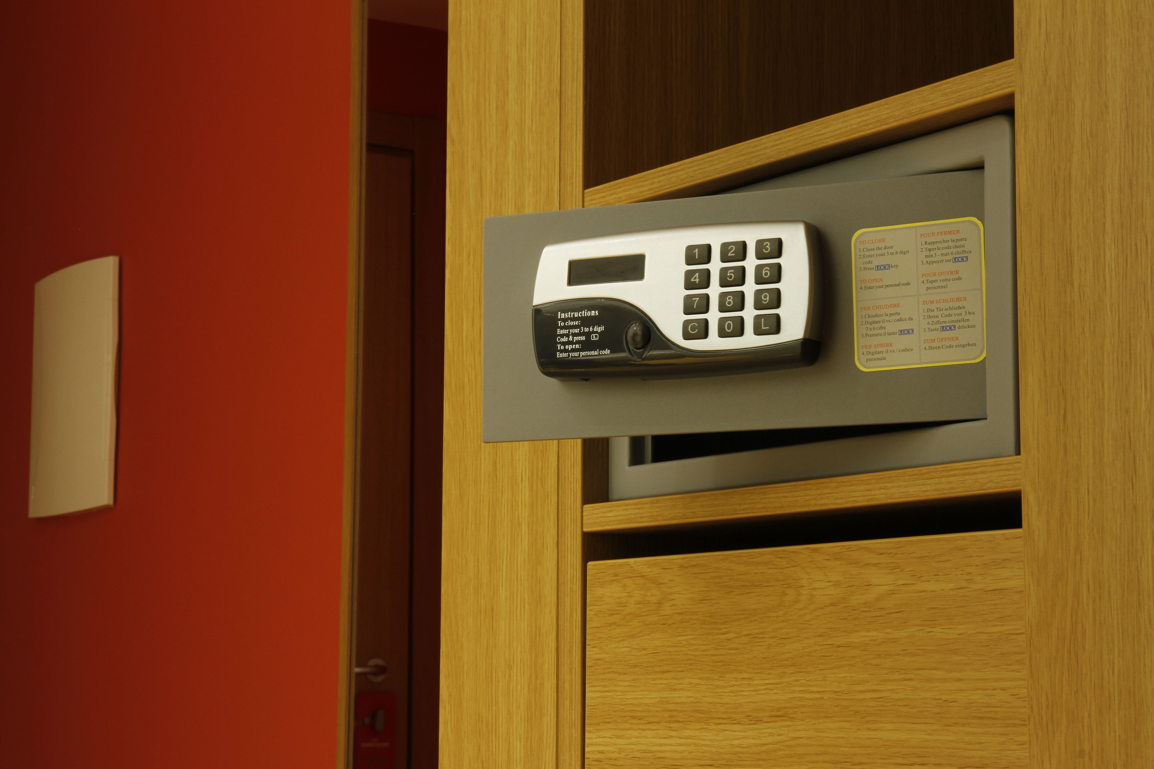 A built-in telephone in a wooden cabinet with a wall-mounted light and a small instruction card.
