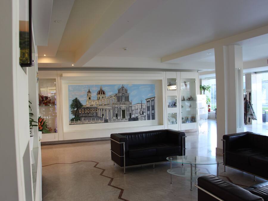 A spacious lobby with a large mural, modern furniture, and a glass coffee table.