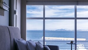 A modern room with a large window offering a view of the sea and distant mountains. - Biwako Hotel (Otsu)