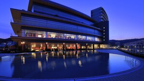 A modern hotel with a pool, multiple floors, and a glass facade reflecting the surroundings. - Biwako Hotel (Otsu)