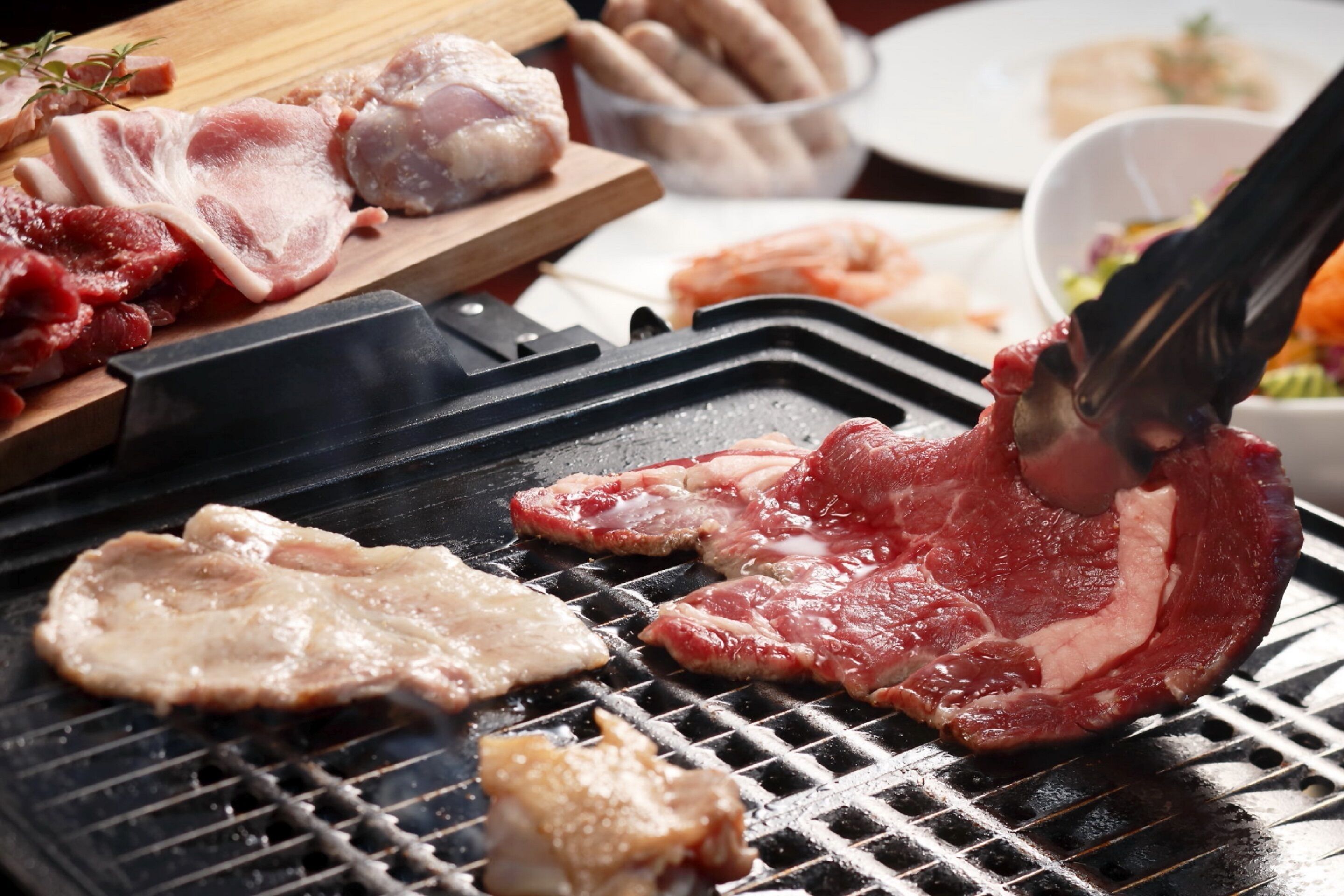 A grill with various meats being cooked.