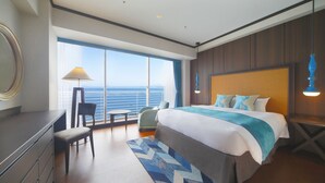 A hotel room with a large bed, a desk, a chair, and a view of the ocean. - Biwako Hotel (Otsu)