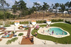 Una piscina al aire libre, sombrillas, sillones reclinables de piscina