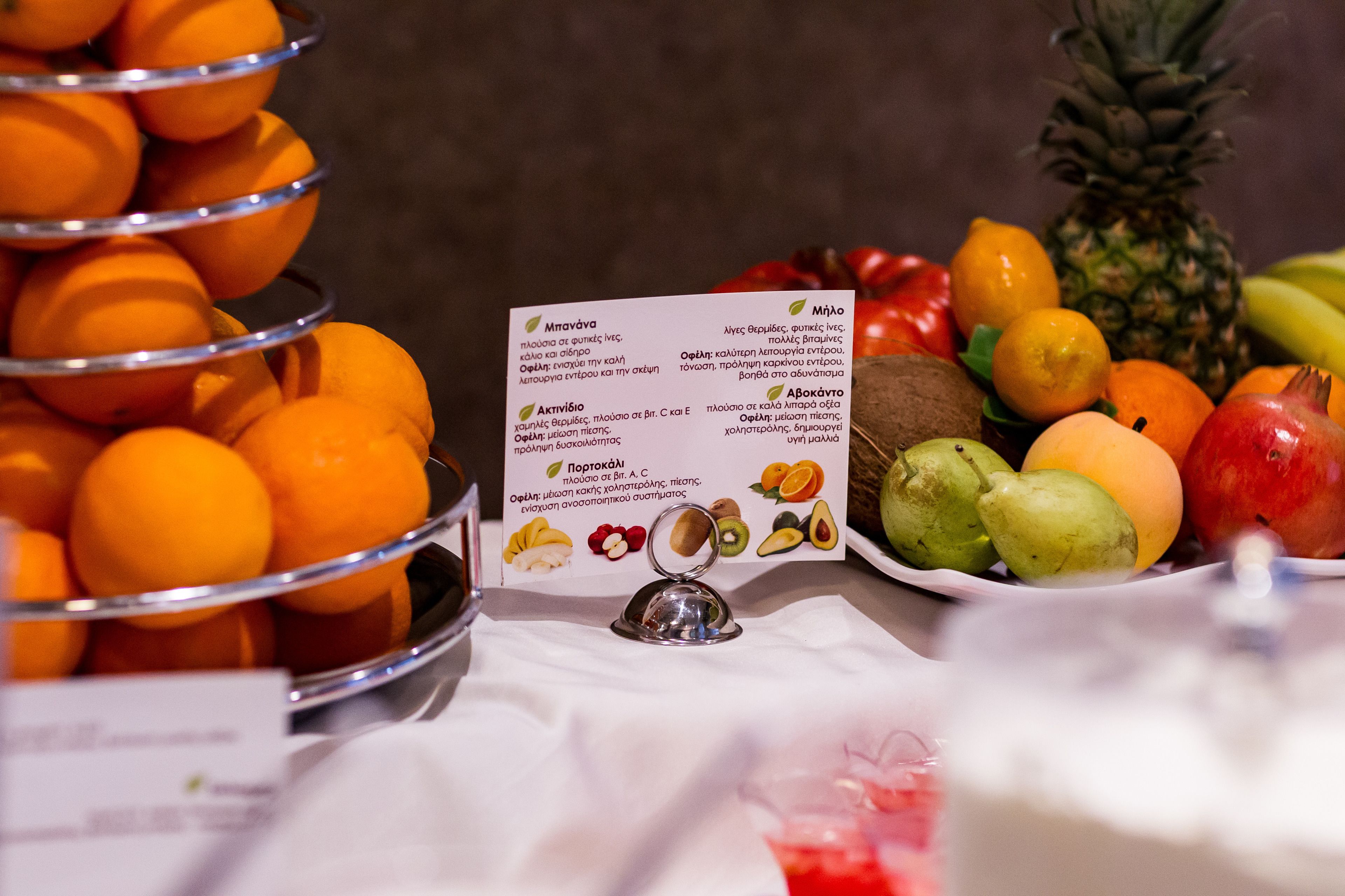 A table with a fruit display and a sign listing fruits and their health benefits.