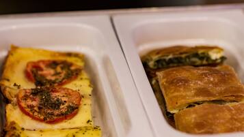 A tray with two types of baked dishes, one with tomatoes and cheese, and another with spinach.