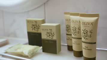 A bathroom shelf with OLIVA care hair and body wash products.