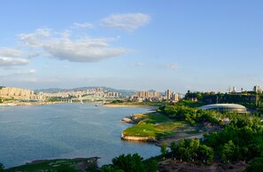 A riverside cityscape with a prominent bridge, a stadium, and dense urban buildings. - Doubletree by Hilton Chongqing Wanzhou (Chongqing)