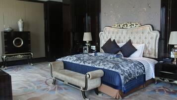 Un dormitorio con una cama grande, un chaise lounge, un tocador y un espejo.