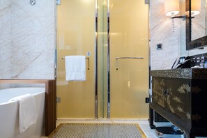 A modern bathroom with a glass-enclosed shower, a marble wall, and a black vanity with a sink. - Doubletree by Hilton Chongqing Wanzhou (Chongqing)