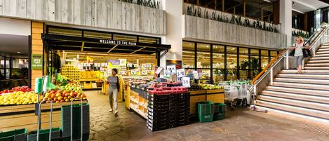 Een supermarkt met groenteafdelingen en winkelwagentjes.