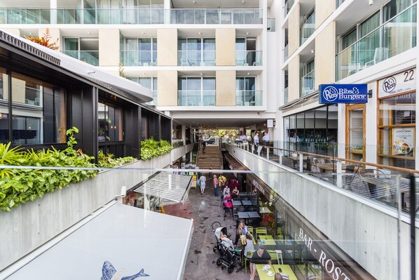 A multi-level atrium with a restaurant, a bar, and a staircase.