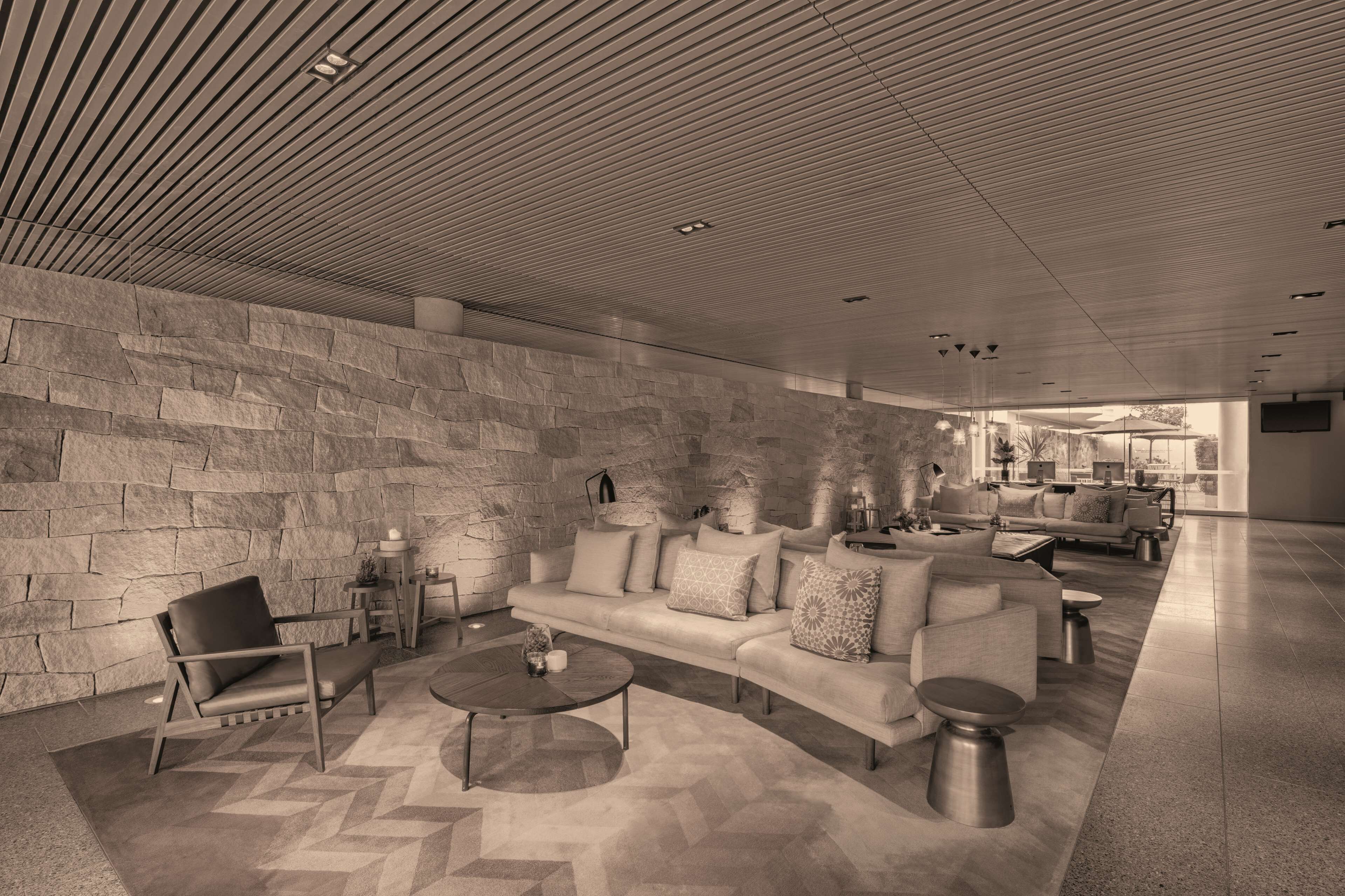 Eine moderne Lobby mit Steinwand, einer Sofagarnitur und einem Couchtisch.