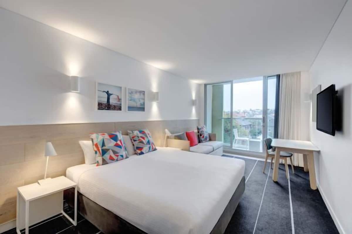 Une chambre d’hôtel moderne avec un grand lit, un bureau et une vue sur la ville.