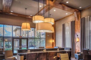 A lobby with a reception desk, seating area, and large windows offering a view of the outside.