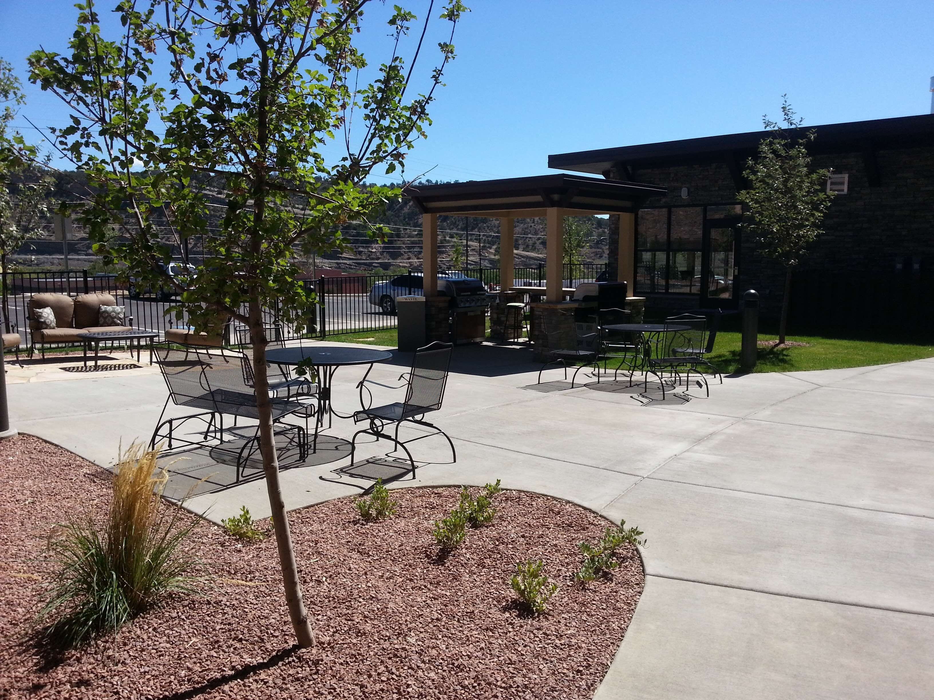 Un patio al aire libre con zona de estar cubierta, una parrilla y una mesa de billar.