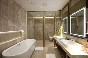 A modern bathroom with a freestanding bathtub, a double sink vanity, and a glass-enclosed shower area.