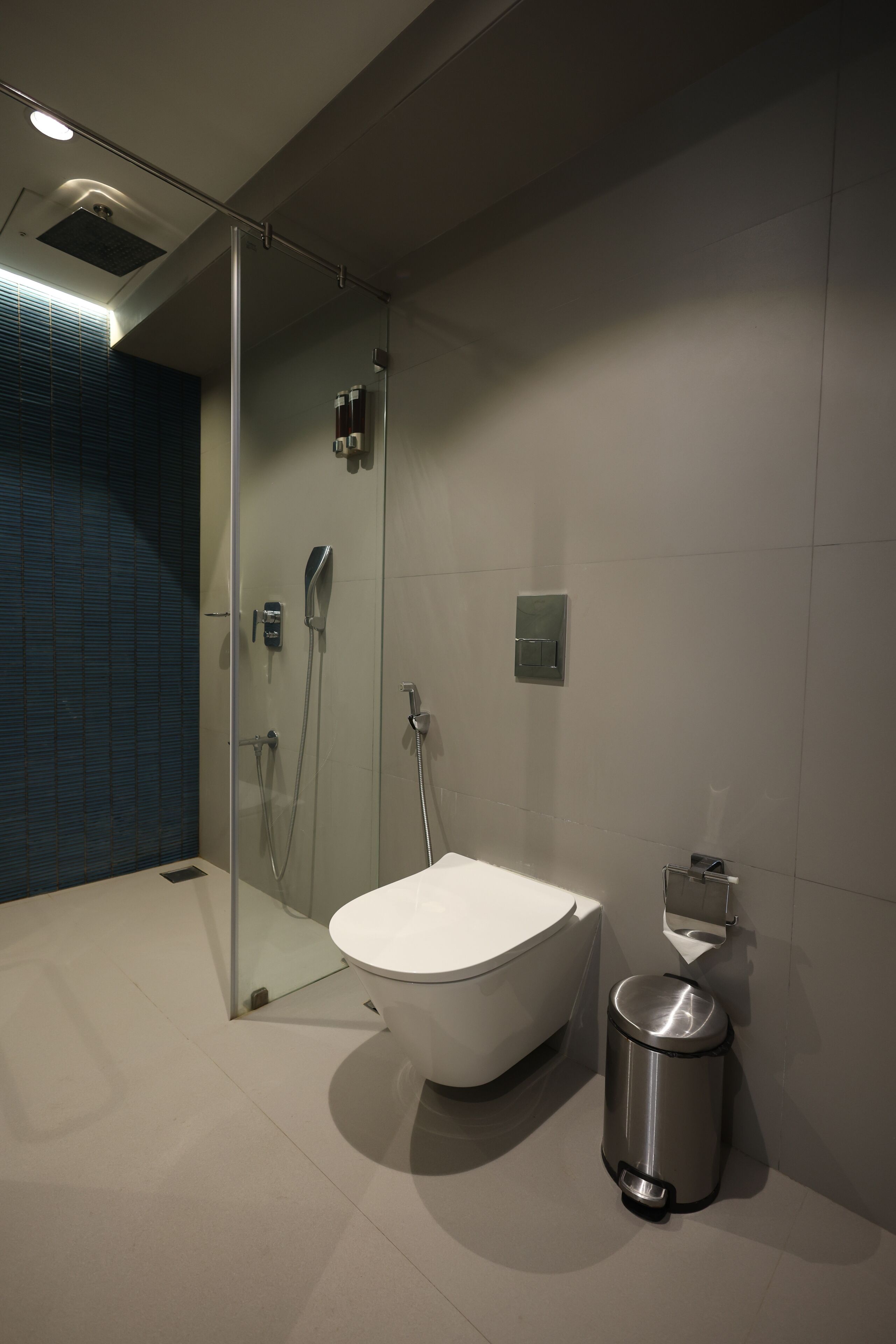 Ein modernes Badezimmer mit einer gläsernen Duschkabine, einer freistehenden Badewanne und einem wandmontierten WC.