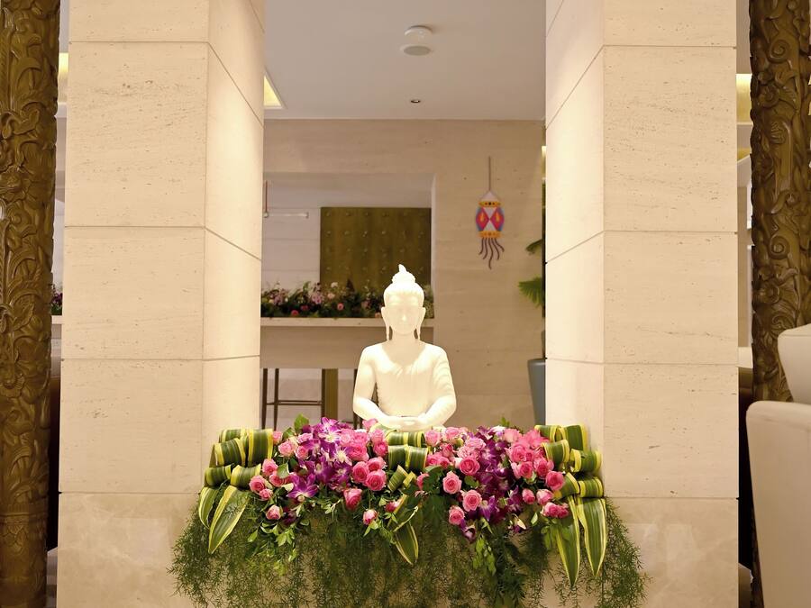 A reception area with a statue, floral arrangements, and a decorative floor pattern.