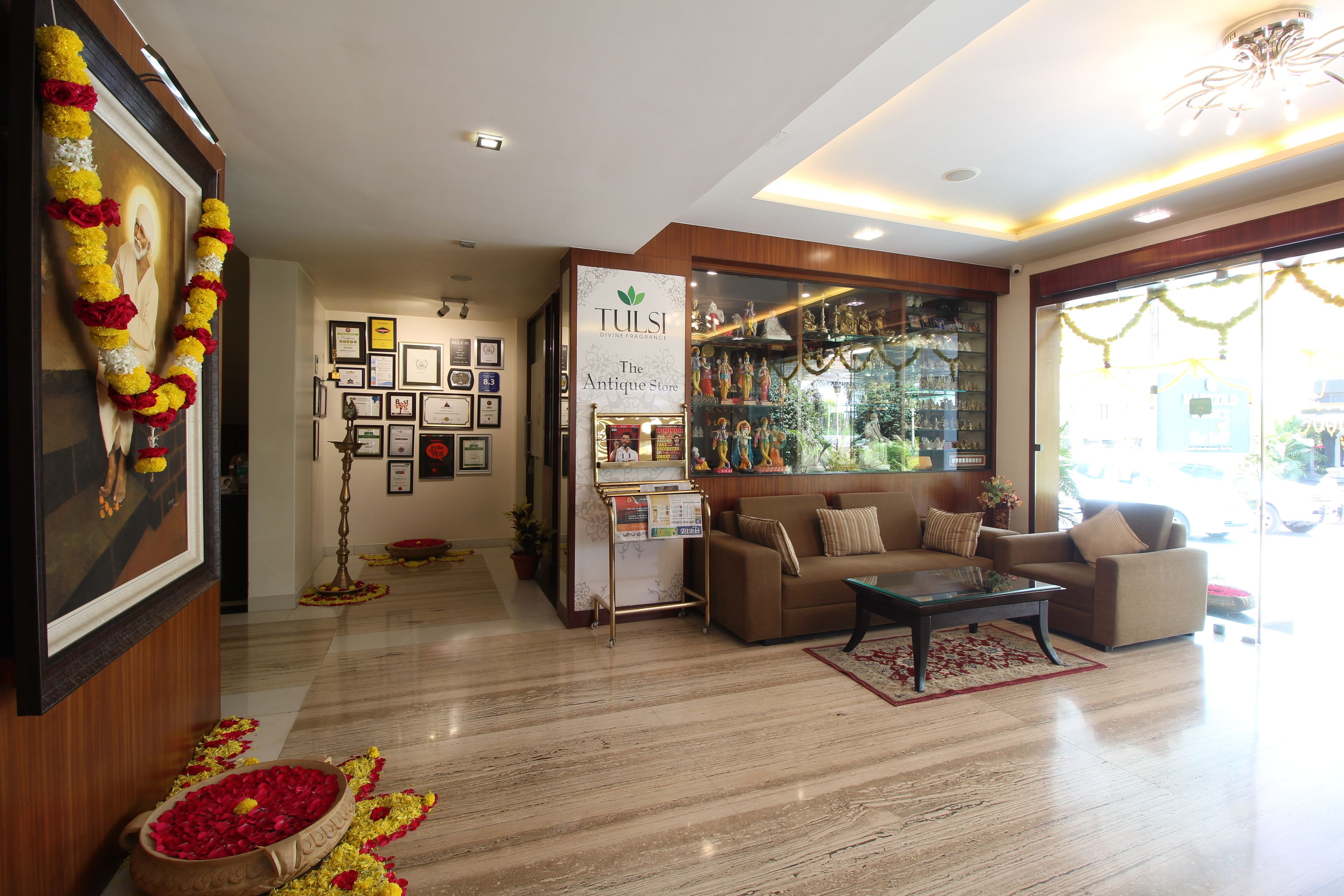 A well-lit lobby with a reception desk, framed certificates, and a coffee table.