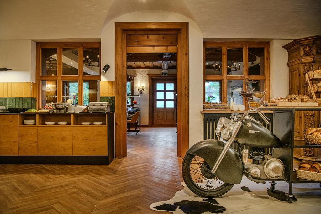 Una cocina con armarios de madera, una motocicleta y un comedor con mesa y sillas.
