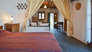 Un dormitorio acogedor con cama, mesita de noche, televisor y ventana.