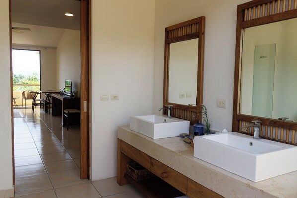 A bathroom with two sinks, wooden vanity, and large mirrors.
