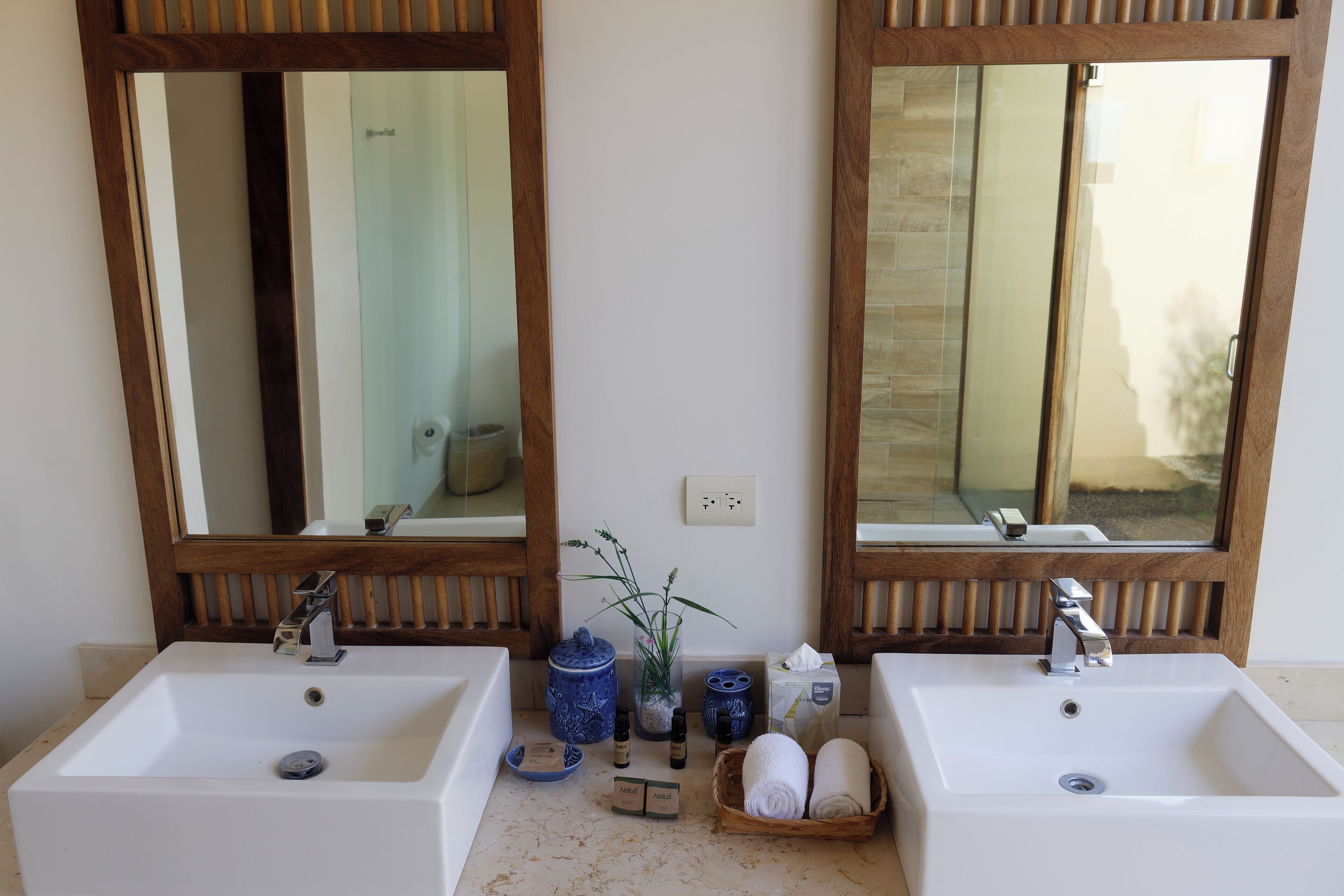 Un baño con dos lavamanos, espejos y una planta pequeña.