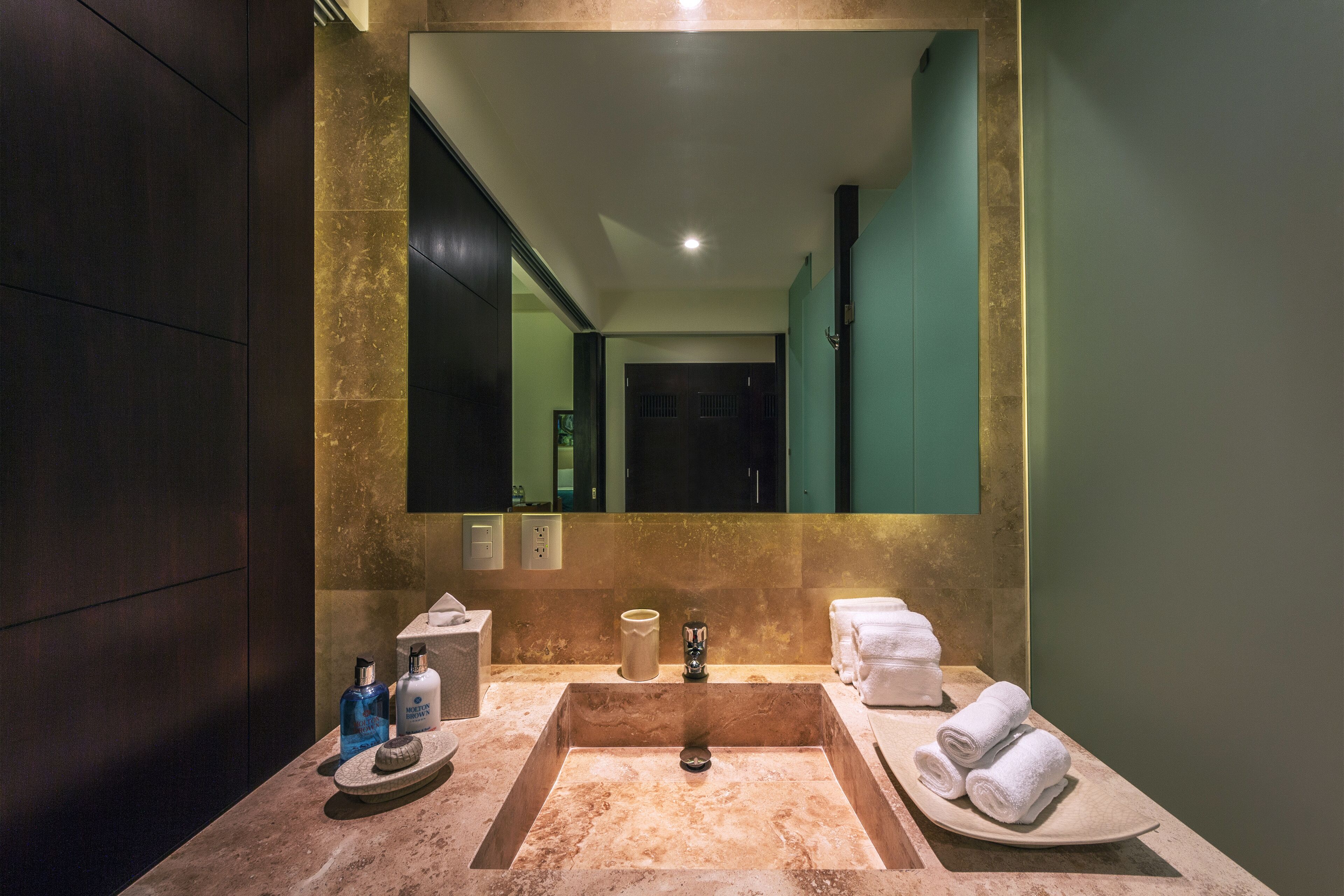 Une salle de bain dotée d’un grand miroir, de deux lavabos et d’un espace coiffeuse.