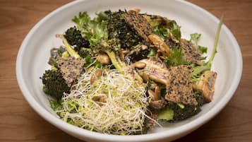A bowl of salad with various vegetables and nuts.