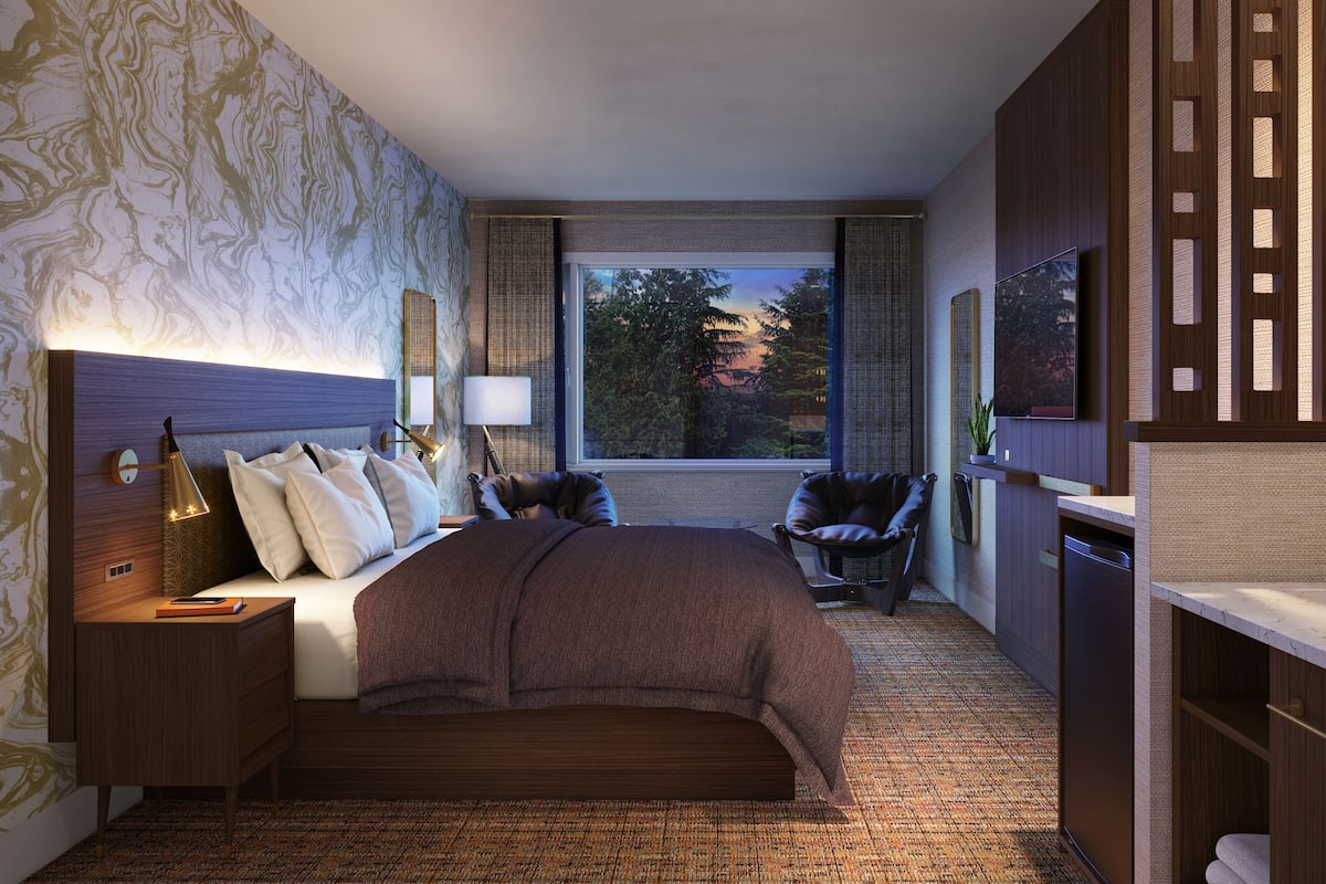 Une chambre d’hôtel moderne équipée d’un grand lit, d’un bureau, d’une chaise et d’une télévision.