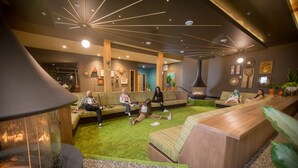 A modern lobby with a central seating area, a fireplace, and various wall decorations. - Hotel Zed Tofino (Tofino)