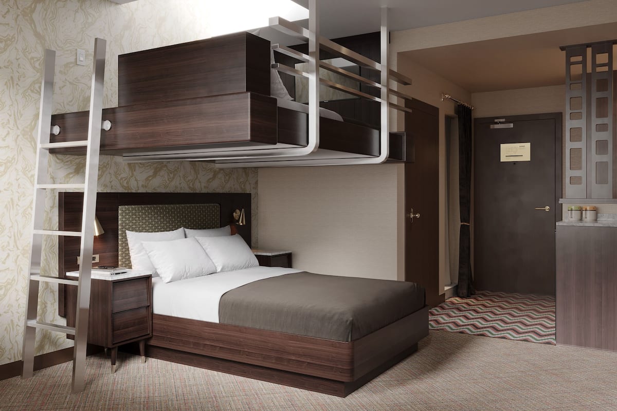 Une chambre avec un lit superposé, une table de chevet, une lampe et une armoire.