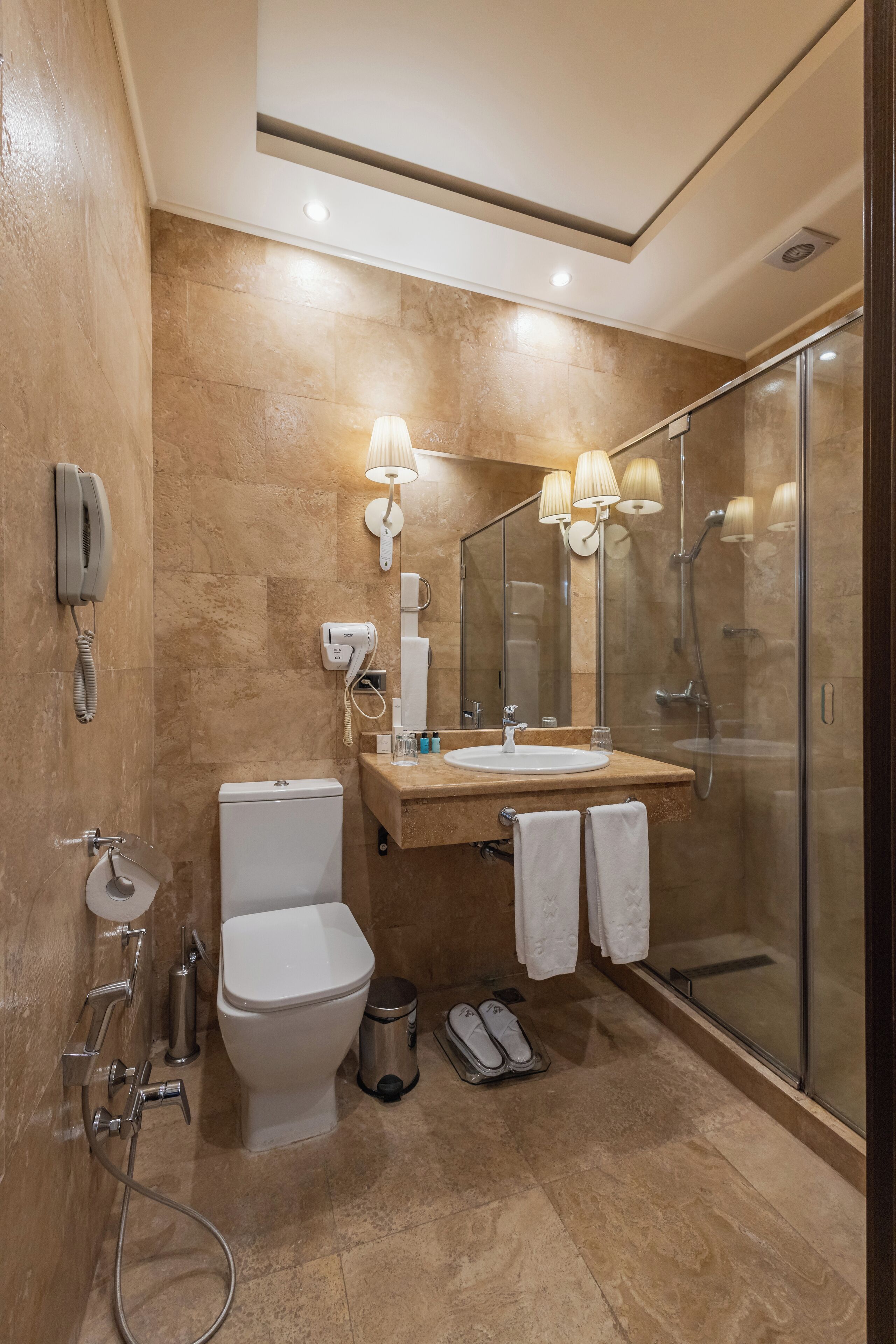 A modern bathroom with a toilet, sink, and shower.