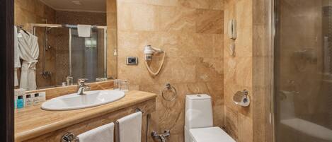Une salle de bain moderne avec un lavabo en marbre, une douche à parois de verre et des toilettes.