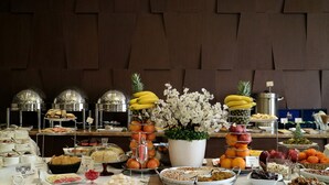 Een buffet met diverse gerechten en een bloempot.