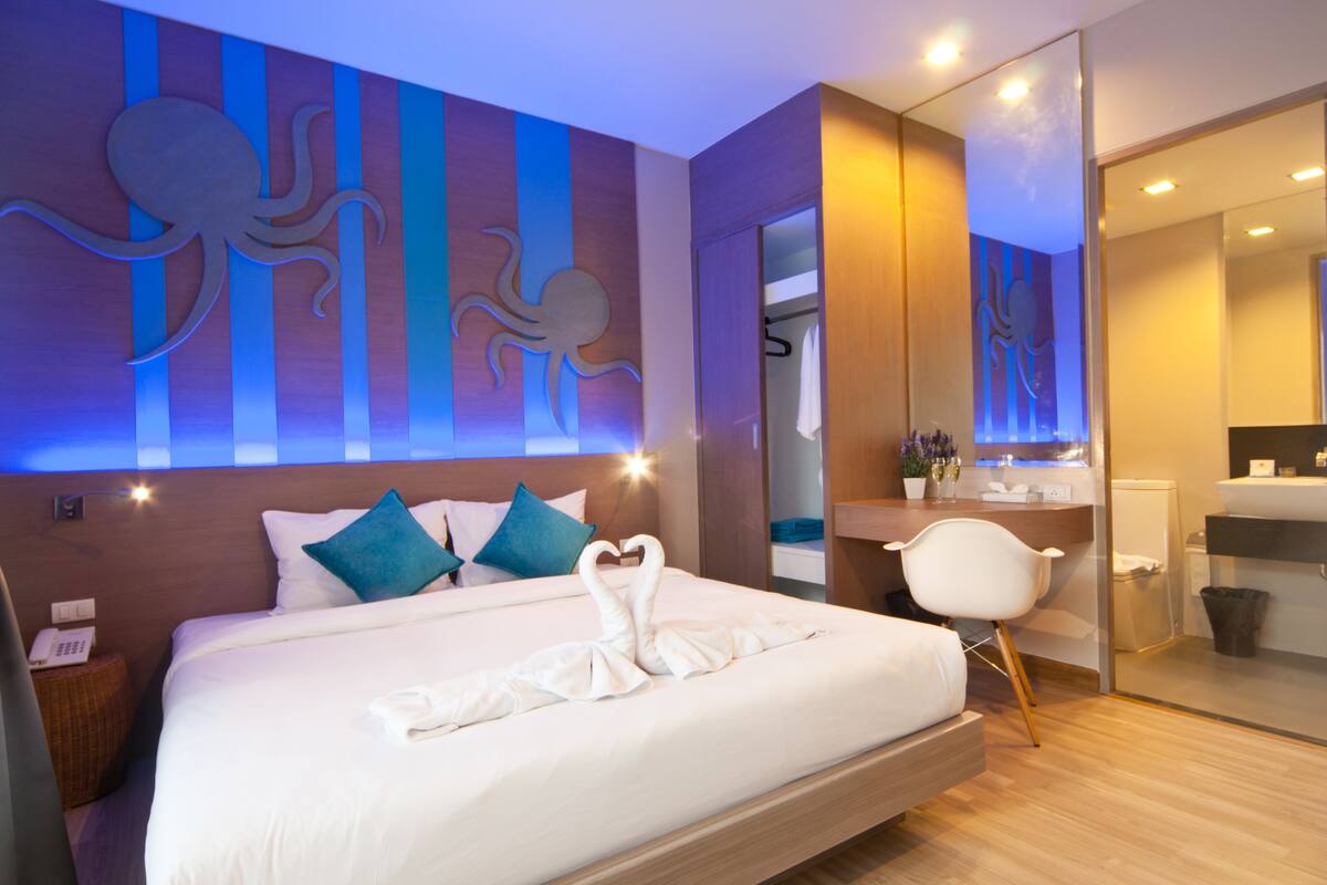 Une chambre d’hôtel moderne avec un grand lit, un bureau et une salle de bain.